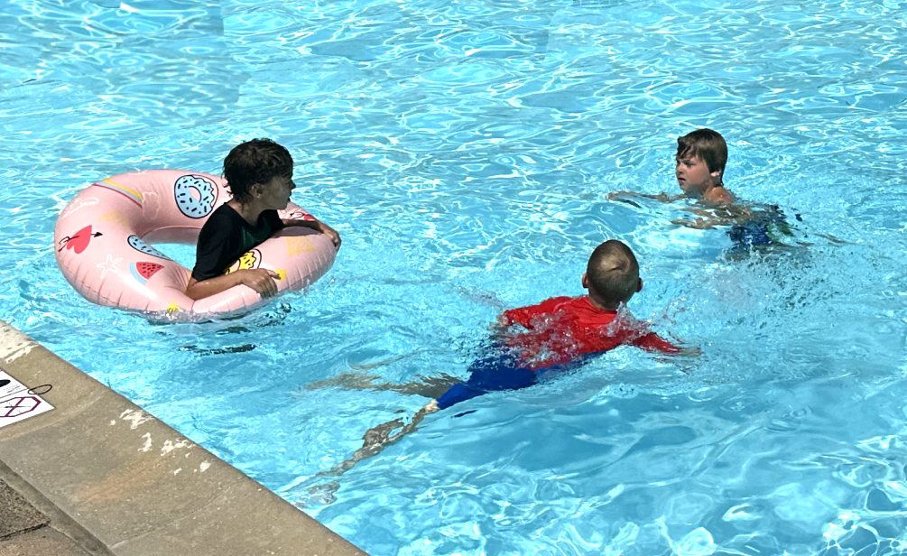 three boys playing in a pool