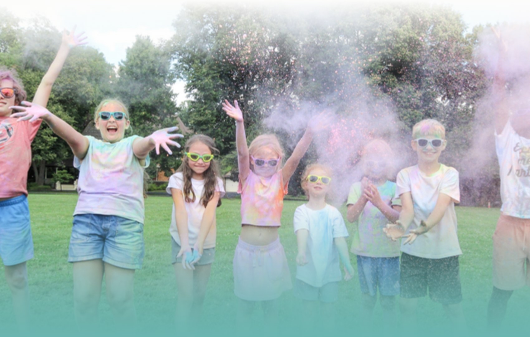 Campers in sunglasses throwing colored powder on the field at DEAN Camps Campers in sunglasses throwing colored powder on the field at DEAN Camps
