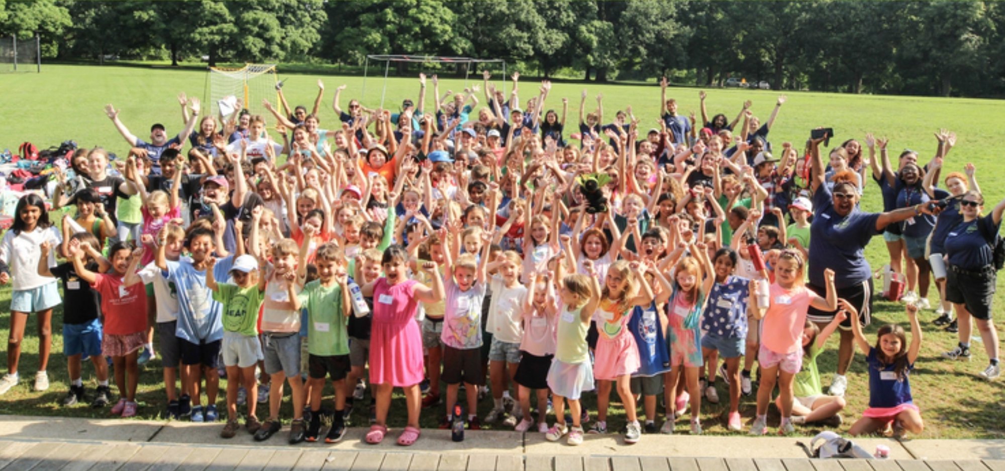 DEAN Camps campers and staff cheering in a summer group photo