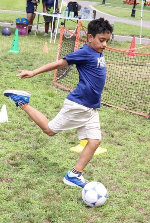 Camper kicking a soccer ball in Sports & Games camp